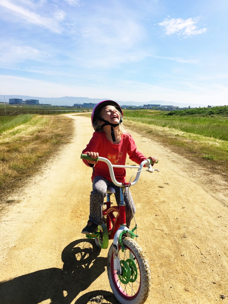 Lillian smiling while riding a bike